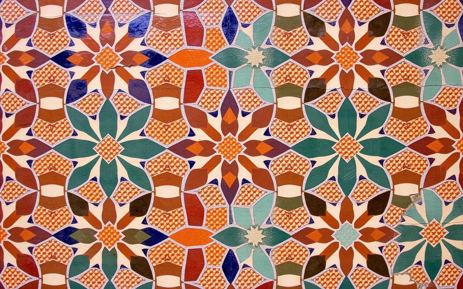 Moorish zellige tile mosaic of interlocking eight-pointed stars and polygons in ochre, indigo, cream and emerald.