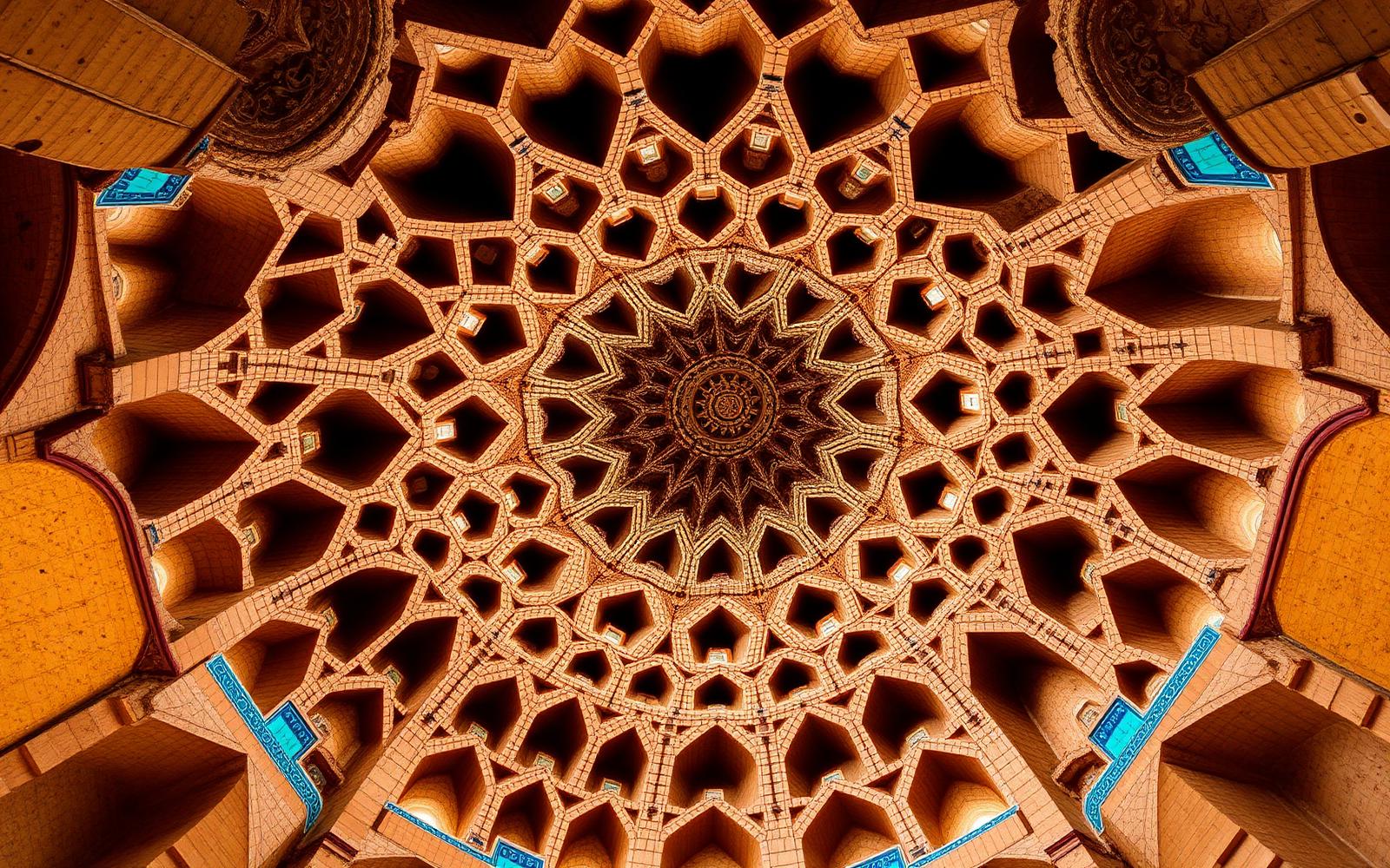 Muqarnas dome vault seen from directly below — a symmetrical geometric honeycomb of stalactite niches in warm sandstone with turquoise accents.